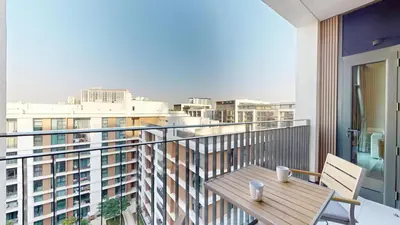 a balcony with a table and chairs and a view of a city at Vacationer l Vibrant 2 Bed l Dubai Hills Mall l Free Pool, Gym in Dubai
