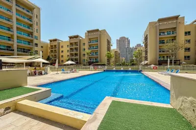 a large swimming pool with buildings in the background at Vacationer l Peaceful 2 Bed l Sheikh Zayed Road l The Greens in Dubai