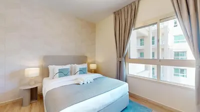 a bedroom with a bed and a large window at Vacationer l Peaceful 2 Bed l Sheikh Zayed Road l The Greens in Dubai