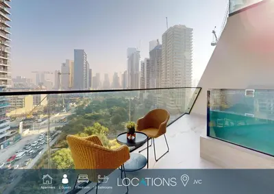 a balcony with two chairs and a table and a city at Locations l Aesthetic 1 Bed l Own Private Pool l Circle Mall in Dubai