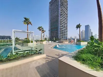 a swimming pool with palm trees and a tall building at Locations l Aesthetic 1 Bed l Own Private Pool l Circle Mall in Dubai