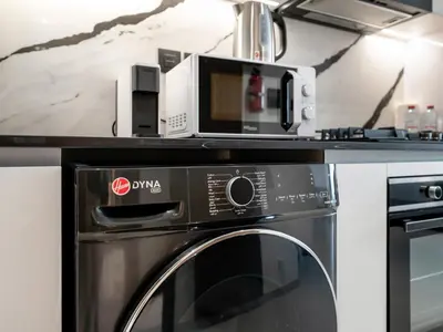 a microwave sitting on top of a oven at Spacious Studio with Balcony & Jacuzzi Trillionaire Residences, Business Bay in Dubai