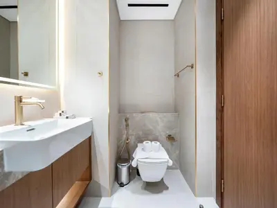 a bathroom with a white toilet and a sink at Spacious Studio with Balcony & Jacuzzi Trillionaire Residences, Business Bay in Dubai