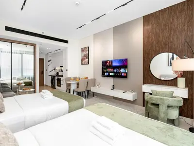 a bedroom with two beds and a living room at Spacious Studio with Balcony & Jacuzzi Trillionaire Residences, Business Bay in Dubai