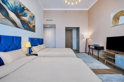 a hotel room with two beds and a flat screen tv at Spacious Luxury Apartments at Burj Vista with Direct Burj Khalifa Views in Dubai