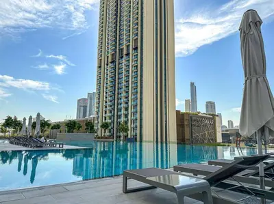 a swimming pool with chairs and a large building at Exclusive Burj Khalifa View Downtown Burj Vista Apartments in Dubai