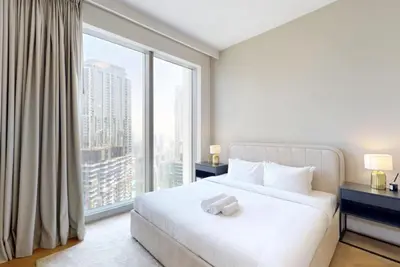 a bedroom with a white bed and a large window at Exclusive Burj Khalifa View Downtown Burj Vista Apartments in Dubai