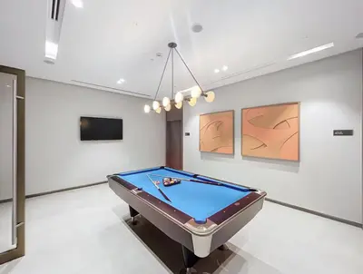 a pool table in a room with paintings at Exclusive Burj Khalifa View Downtown Burj Vista Apartments in Dubai