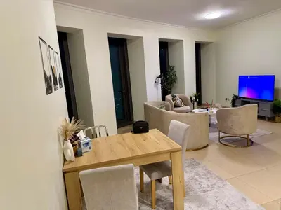 a living room with a wooden table and a couch at Burj Khalifa View Apartments, Burj Vista Tower - Downtown in Dubai