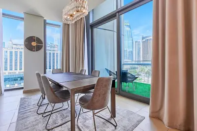 a dining room with a table and chairs and a large window at Burj Khalifa View Apartments, Burj Vista Tower - Downtown in Dubai