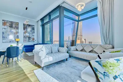 a living room with white furniture and a large window at Burj Khalifa View Apartments, Burj Vista Tower - Downtown in Dubai