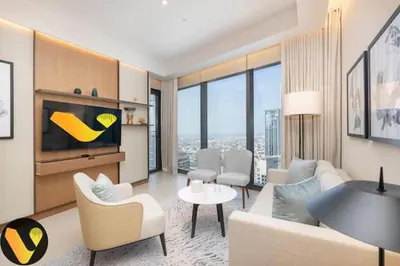 a living room with a couch and a tv at Vogue Downtown Address Residence near Burj Khalifa and Dubai Mall, Two Bedroom Apartment with Balcony and City Skyline view, Access to all Amenities in Dubai