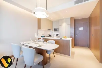 a kitchen and dining room with a white table and chairs at Vogue Downtown Address Residence near Burj Khalifa and Dubai Mall, Two Bedroom Apartment with Balcony and City Skyline view, Access to all Amenities in Dubai