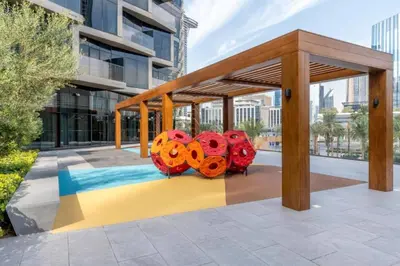 a pavilion with orange and red sculptures on a sidewalk at Vogue Downtown Address Residence near Burj Khalifa and Dubai Mall, Two Bedroom Apartment with Balcony and City Skyline view, Access to all Amenities in Dubai