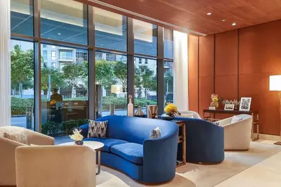 a living room with a blue couch and chairs at Vogue Downtown Address Residence near Burj Khalifa and Dubai Mall, Two Bedroom Apartment with Balcony and City Skyline view, Access to all Amenities in Dubai