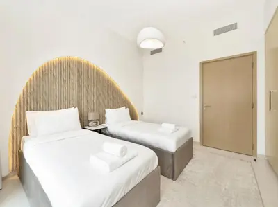 two beds in a hotel room with white walls at Prime Burj Vista Residences with Burj Khalifa View in Dubai