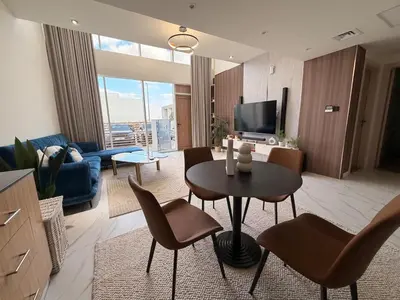 a living room with a table and chairs and a tv at Quiet Villa 3 Br in Dubai