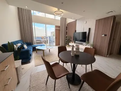 a living room with a table and chairs and a television at Quiet Villa 3 Br in Dubai
