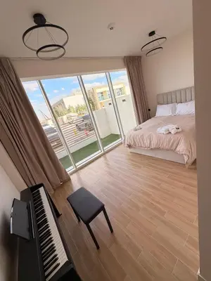 a bedroom with a bed and a piano and a window at Quiet Villa 3 Br in Dubai
