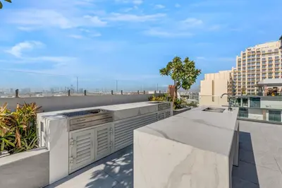 a kitchen with white counter tops on a balcony at Waves - Boho Style Chic Studio With Balcony in JVC in Dubai