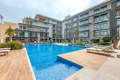 a swimming pool in front of a building at Waves - Boho Style Chic Studio With Balcony in JVC in Dubai