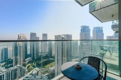 a balcony with a blue table and a view of a city at TRPS - The Grand, Dubai Creek Harbour - Luxury High-Floor 1BR, Creek & Skyline View in Dubai