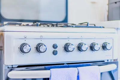 a white stove top oven with towels on it at TRPS - The Grand, Dubai Creek Harbour - Luxury High-Floor 1BR, Creek & Skyline View in Dubai
