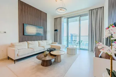 a living room with a couch and a table at TRPS - The Grand, Dubai Creek Harbour - Luxury High-Floor 1BR, Creek & Skyline View in Dubai