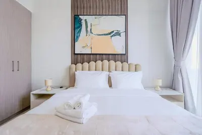 a bedroom with a large white bed with two towels on it at TRPS - The Grand, Dubai Creek Harbour - Luxury High-Floor 1BR, Creek & Skyline View in Dubai