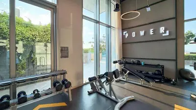 a gym with a bench with weights and a window at TRPS - The Grand, Dubai Creek Harbour - Luxury High-Floor 1BR, Creek & Skyline View in Dubai