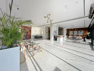 a lobby with plants and tables in a building at Elegant 1BR with Pool Gym & Burj Khalifa Views in Dubai