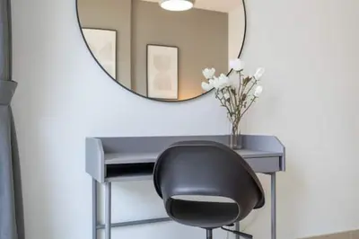 a desk with a black chair and a mirror at Vogue Downtown Bellevue Towers near Burj Khalifa and Dubai Mall, One bedroom Apartment with Balcony and City view, Access to all Amenities in Dubai