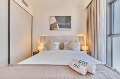 a bedroom with a white bed with two pillows on it at Modern 1BR with Palm View Dubai Harbour in Dubai