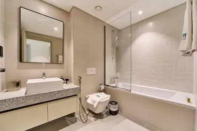 a bathroom with a sink and a tub and a mirror at Modern 1BR with Palm View Dubai Harbour in Dubai
