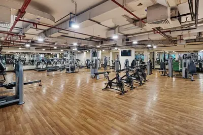 a gym with a lot of treadmills and machines at Modern 1BR in JVC, 2 Baths, Pool & Gym, Fully Equipped Kitchen in Dubai