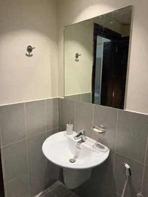 a bathroom with a white sink and a mirror at Modern 1BR in JVC, 2 Baths, Pool & Gym, Fully Equipped Kitchen in Dubai