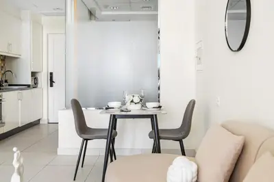 a kitchen and dining room with a table and chairs at Amazing Studio with Balcony & Marina Eye Views in Dubai