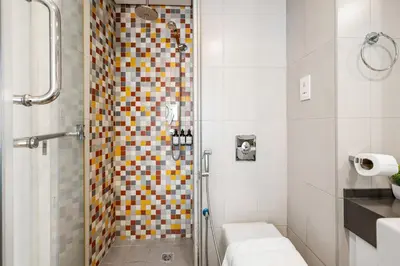 a bathroom with a shower with colorful tiles at Amazing Studio with Balcony & Marina Eye Views in Dubai
