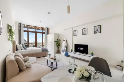 a living room with a couch and a tv at Amazing Studio with Balcony & Marina Eye Views in Dubai