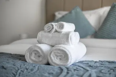 a pile of towels stacked on top of a bed at Amazing Studio with Balcony & Marina Eye Views in Dubai