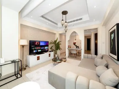 a living room with a couch and a tv at Skyline Select 1 Bedroom Apartment I Burj Khalifa View I Souk Al Bahar Downtown I Parking, Gym, Wi-Fi & Pool in Dubai