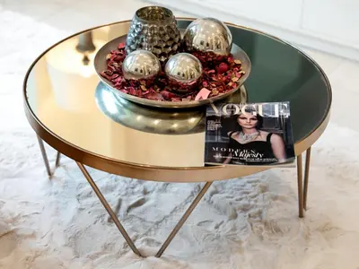 a gold table with a magazine and a bowl of ornaments at Skyline Select 1 Bedroom Apartment I Burj Khalifa View I Souk Al Bahar Downtown I Parking, Gym, Wi-Fi & Pool in Dubai