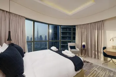 a bedroom with a bed with a view of the city at HSHOME - Luxury 3 Bedroom Apartment with Burj Khalifa & Stunning Skyline View in Dubai