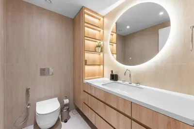 a bathroom with a sink and a toilet and a mirror at StayShort - Chic Discovery Gardens 1Bed that Sleeps 2 in Dubai