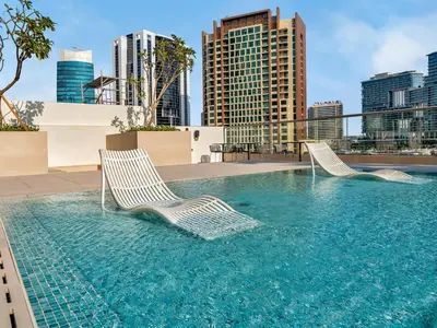 two lounge chairs in a pool on the roof of a building at Large modern STUDIO in STERLING DOWNTOWN I DUBAI MALL I Sleeps 4 I Amazing Balcony in Dubai