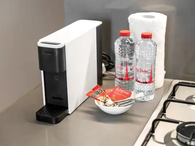 a coffee maker and two bottles of water on a counter at Large modern STUDIO in STERLING DOWNTOWN I DUBAI MALL I Sleeps 4 I Amazing Balcony in Dubai