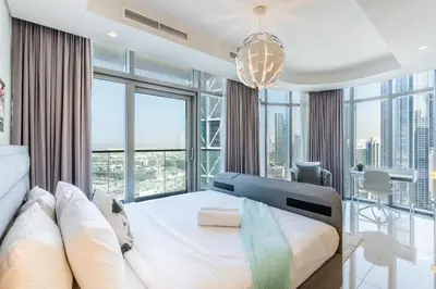 a bedroom with a bed and large windows at RH - Luxury 2BR at Paramount Midtown, Burj Khalifa View in Dubai