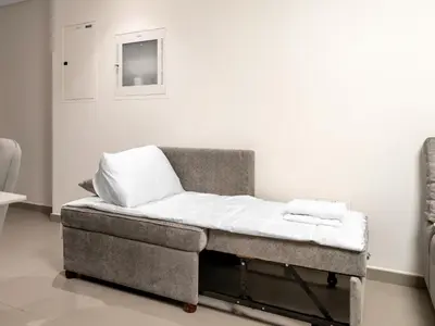 a bed sitting in a room next to a wall at Downtown Dubai 1BR Apartment I Balcony I Dubai Mall Access in Dubai