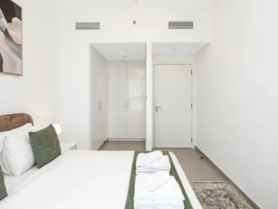 a white bedroom with a bed and a closet at Downtown Dubai 1BR Apartment I Balcony I Dubai Mall Access in Dubai