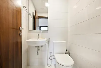 a white bathroom with a toilet and a sink at Modern 1BDR Apt With Balcony Pool Access And JVC in Dubai